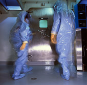 Winnipeg, Manitoba. Fully garbed in suits to protect them from dangerous microbiological agents such as anthrax, SARS, and Ebola viruses,  workers approach the outer hatch of the Level IV microbiology lab at the Canadian Health Sciences Centre.