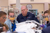 Canadian Healthcare / Toronto, Canada.

Air ambulance paramedic Michael Chad grimaces as he helps transfer a large middle-aged man with life-threatening abdominal injuries to the trauma room table.