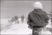 From RETURN TO NITASSINAN/HOMELAND.
Andrew Family Camp, Dominion Lake, Nitassinan/Labrador. Trevor Hurley watches a helicopter depart after it has dropped family members and supplies. The Andrews spend several months a year in the bush reclaiming their traditional Innu culture and passing it on to their children and grand-children.