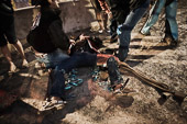 Small Town Rodeo Culture / Rawhide Rodeo, Lindsay Ontario 2009. Tended by friends and a rodeo medic, Brazilian bull rider Cly Neto, lies splayed on the ground after being hastily carried from the ring after his bull slipped in the mud and fell on him.